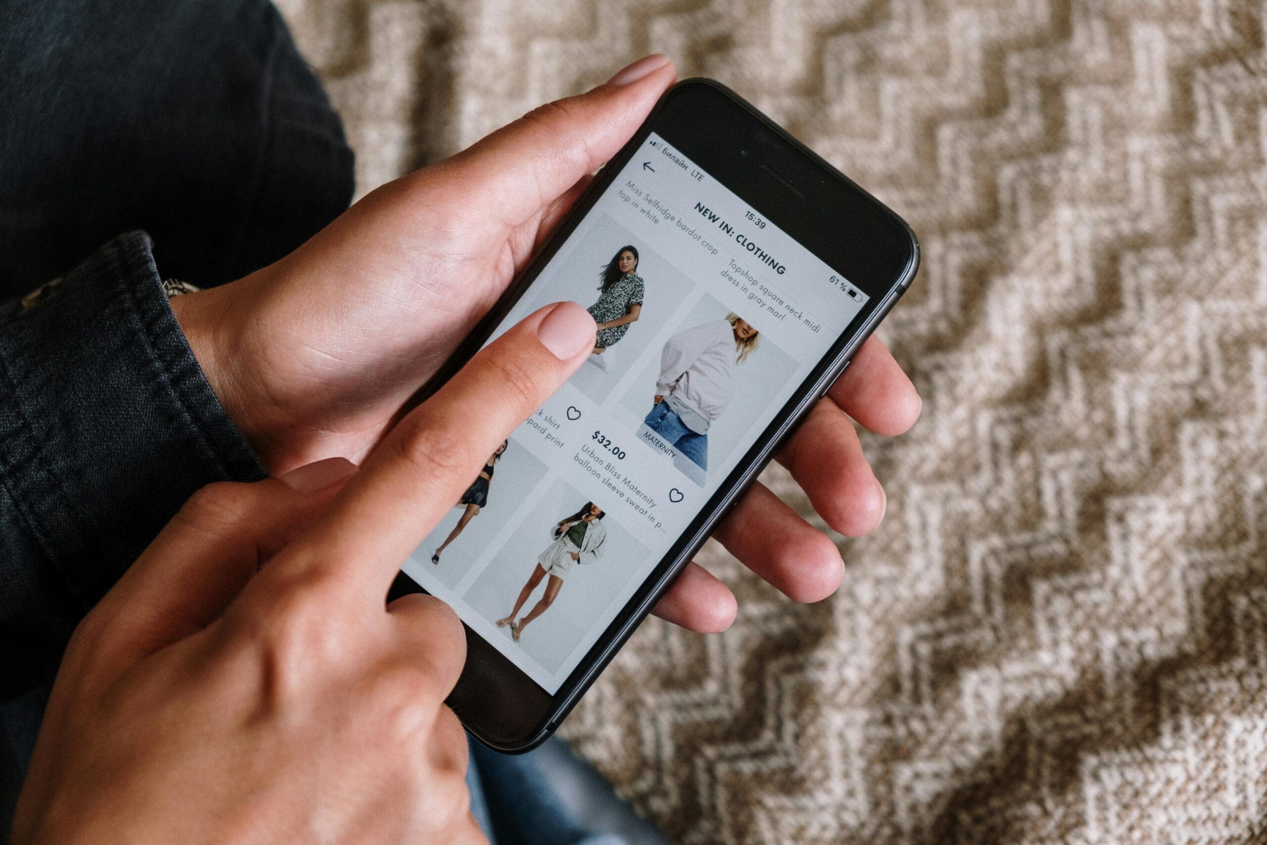 Person browsing a mobile fashion store interface, demonstrating seamless Shopify user experience on mobile.