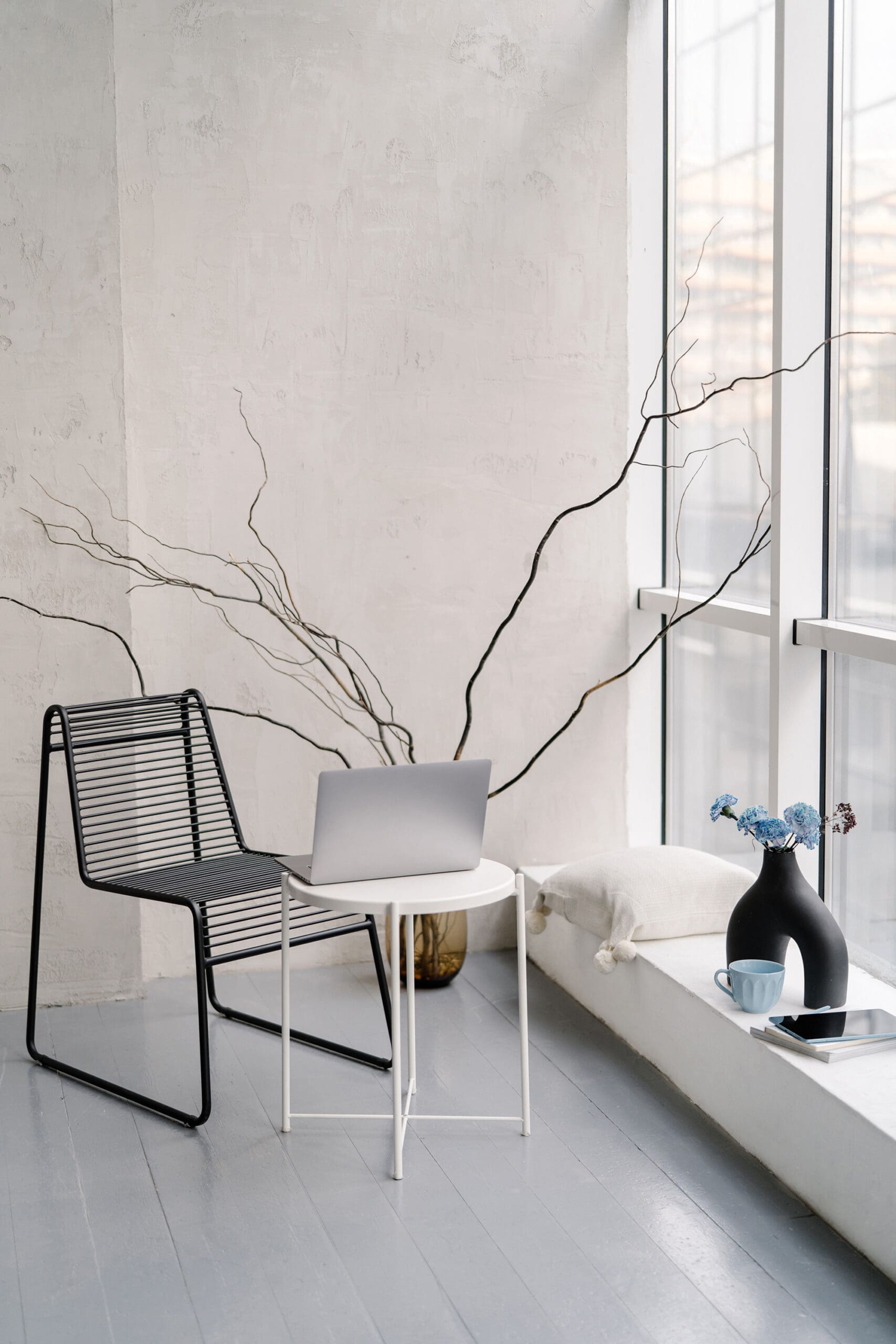 Minimal home office workspace with laptop on a white side table — small business tech stack and tools guide for creative entrepreneurs